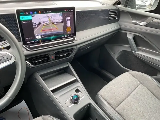 Vue intérieure côté passager du Volkswagen Tiguan 2024 avec écran tactile affichant la caméra de recul et sellerie tissu gris noir.