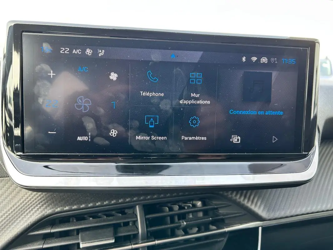 Écran tactile central de la Peugeot 208 Hybrid 110 e-DCS6 Allure 2024, affichant les réglages climatisation et applications.