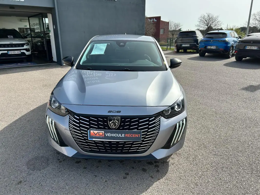 Vue avant d'une Peugeot 208 gris métallisé 2024 avec calandre noire et feux LED verticaux distinctifs.