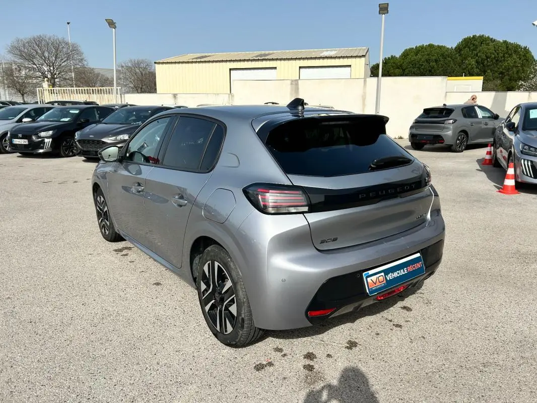 Peugeot 208 Hybrid gris vue 3/4 arrière droit, avec feux arrière LED et jantes alliage distinctives.