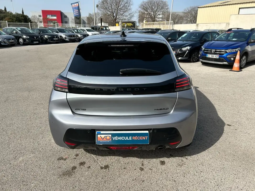 Vue arrière d'une Peugeot 208 Hybrid 110 e-DCS6 Allure gris 2024, avec feux arrière LED et lunette teintée.
