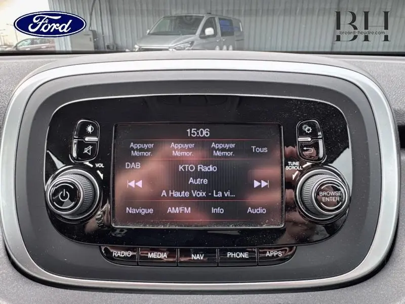 Écran tactile central de la console multimédia d'une Fiat 500X noir Cinéma pastel, affichant la radio KTO à 15h06.