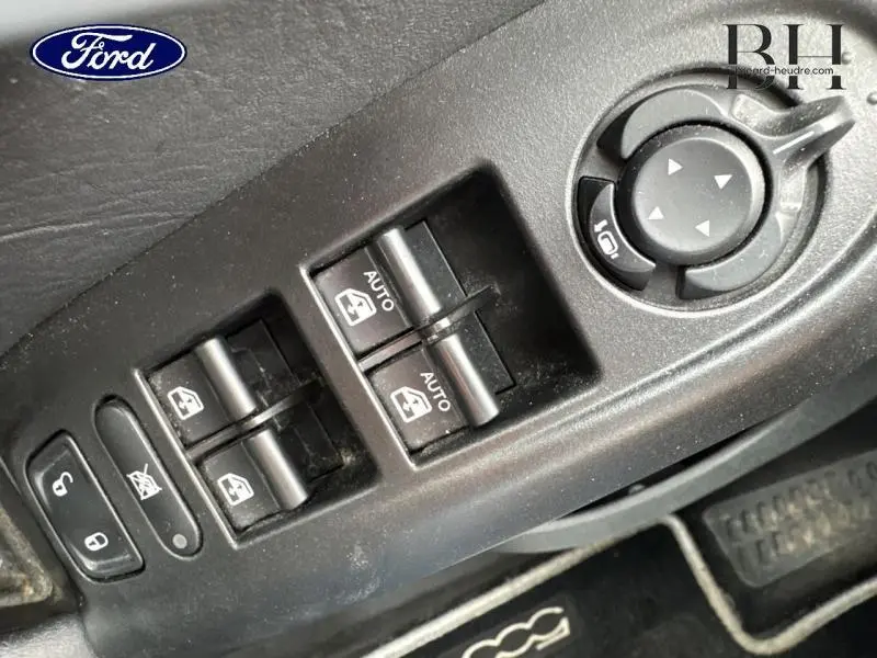 Panneau de commandes des vitres et rétroviseurs côté conducteur en plastique noir dans un Fiat 500X noir Cinéma pastel.