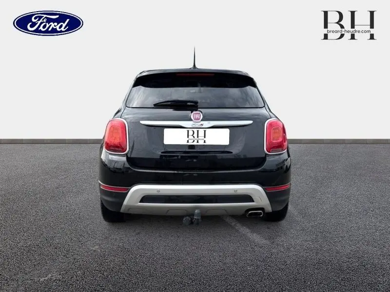 Vue arrière d'une FIAT 500X noire Cinéma pastel avec bouclier arrière gris et attelage de remorque visible.