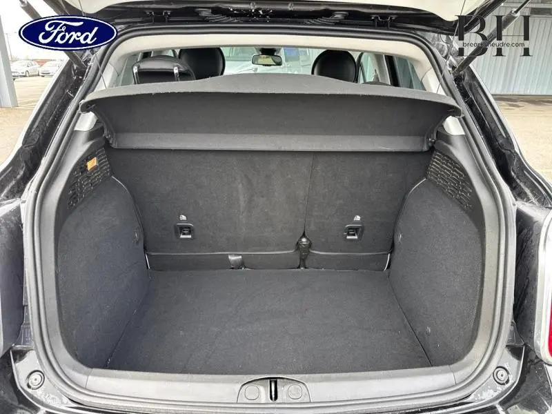 Coffre ouvert vu de l'arrière d'une FIAT 500X noir Cinéma pastel extra-série avec tablette cache-bagages.