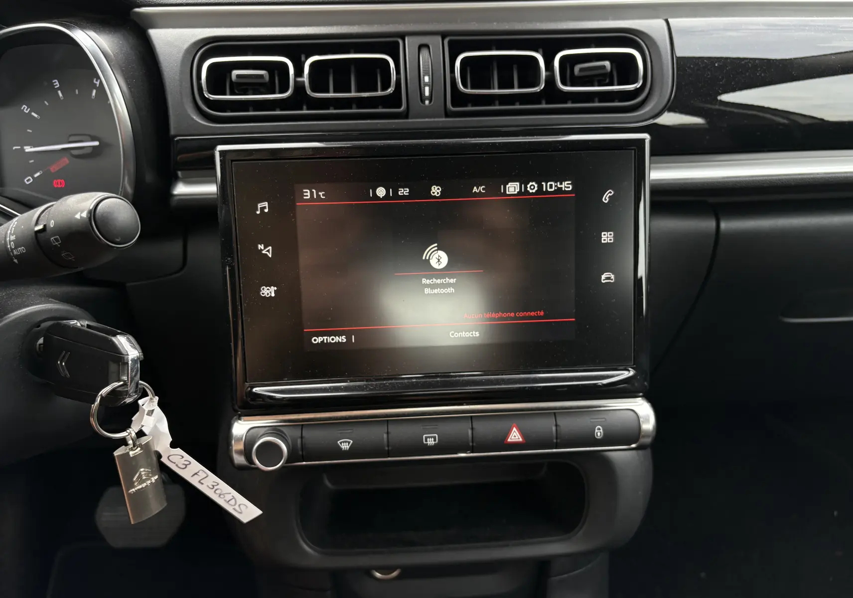Vue rapprochée du tableau de bord de la Citroën C3 beige 2019, mettant en valeur l'écran tactile central et les commandes.