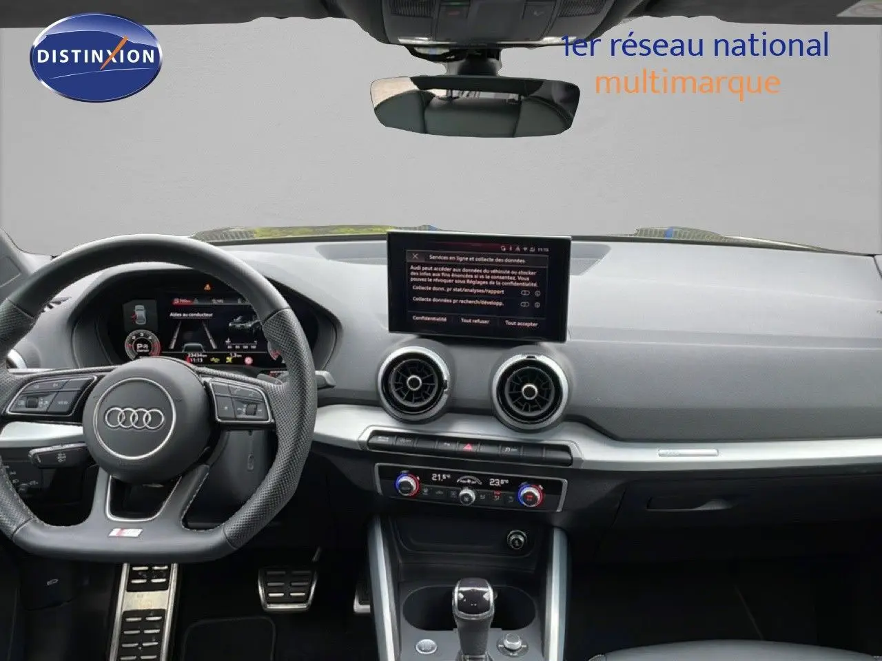 Vue intérieure de l'Audi Q2 S-Line 2025, tableau de bord noir avec volant sport et écran central tactile.