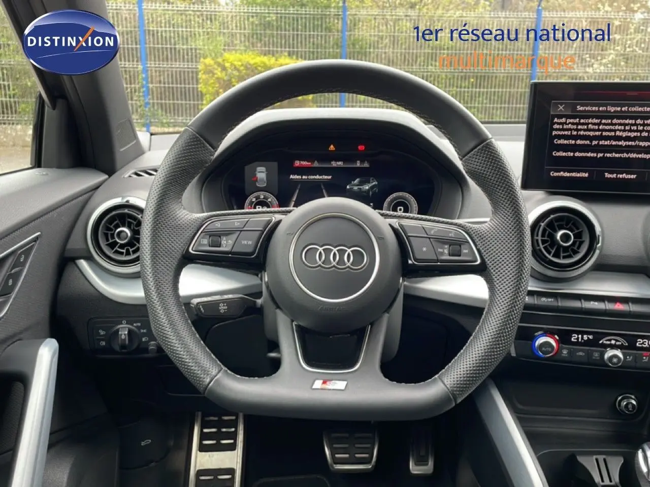 Vue intérieure centrée sur le volant perforé et le tableau de bord numérique de l'Audi Q2 S-Line noir Mito Metal.