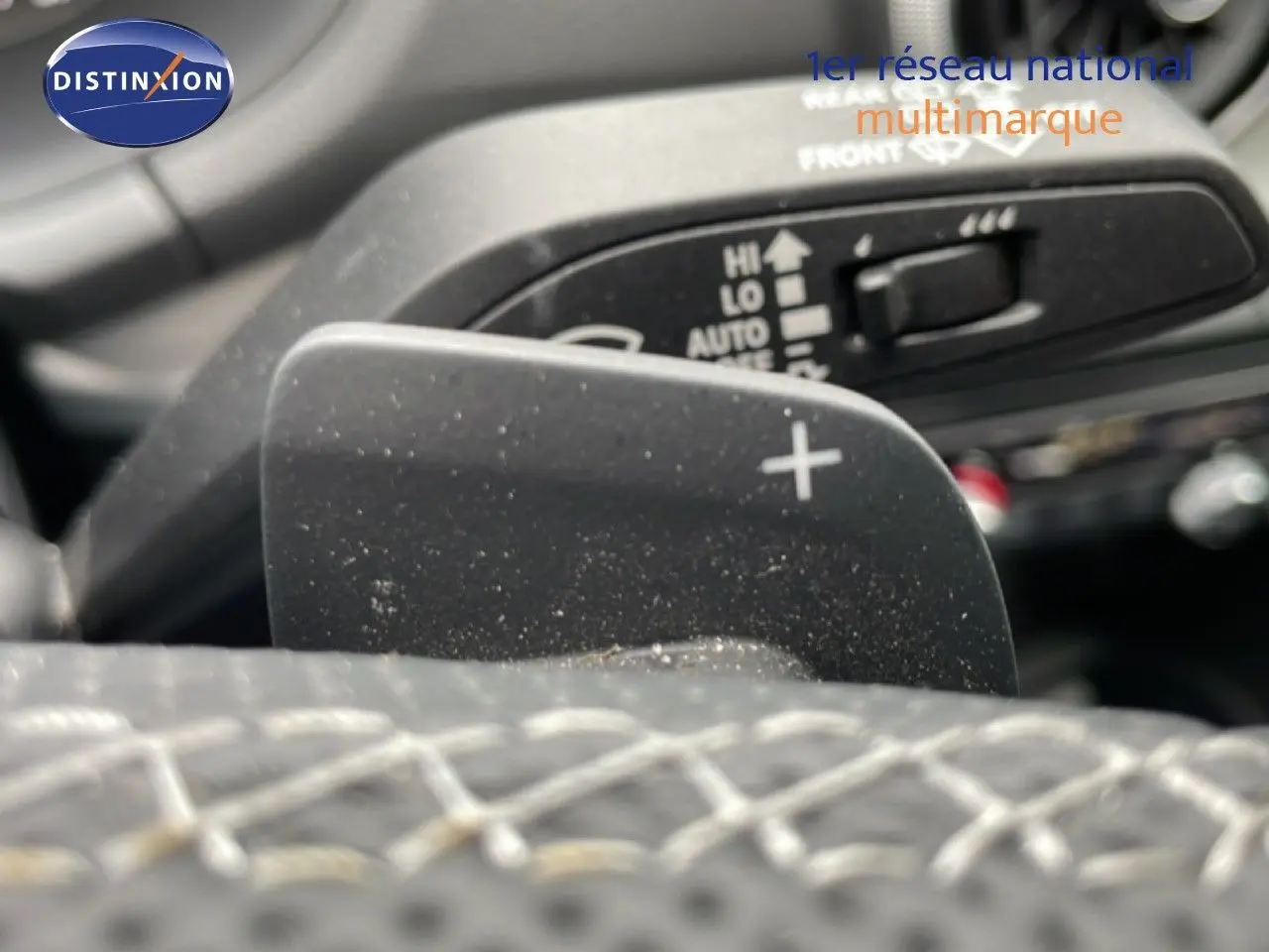 Gros plan sur la palette de changement de vitesse + du volant cuir noir de l'Audi Q2 2025 en intérieur.