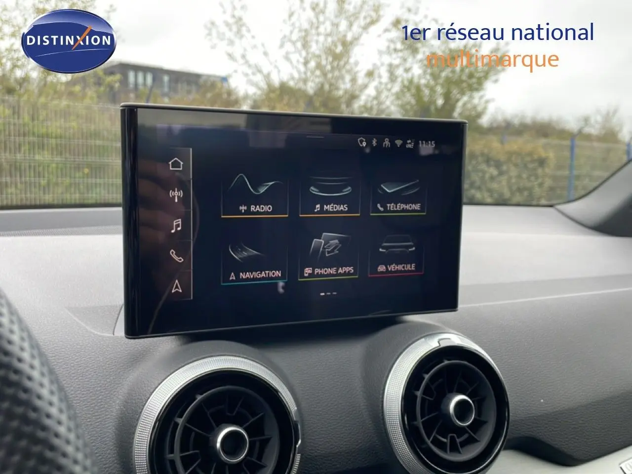 Écran tactile central de l’Audi Q2 35 2.0 TDI S-Line 2025, intérieur noir avec aérateurs ronds argentés.