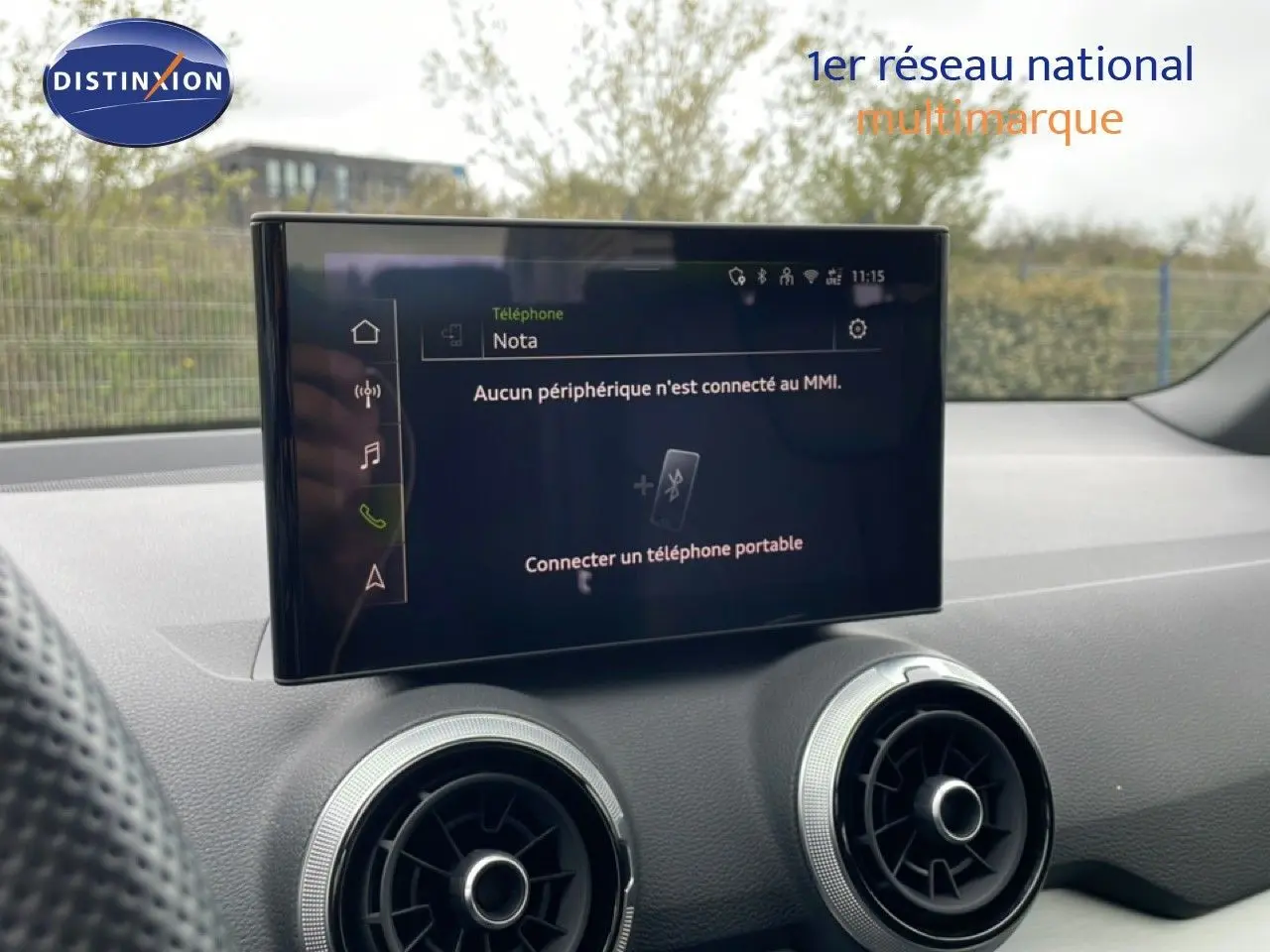 Écran tactile central et aérateurs ronds dans l’habitacle d’un Audi Q2 noir mito metal, vue intérieure avant.