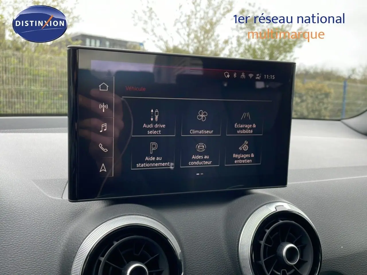 Vue intérieure de l'Audi Q2 2025, écran central tactile avec menu des aides à la conduite et climatisation.