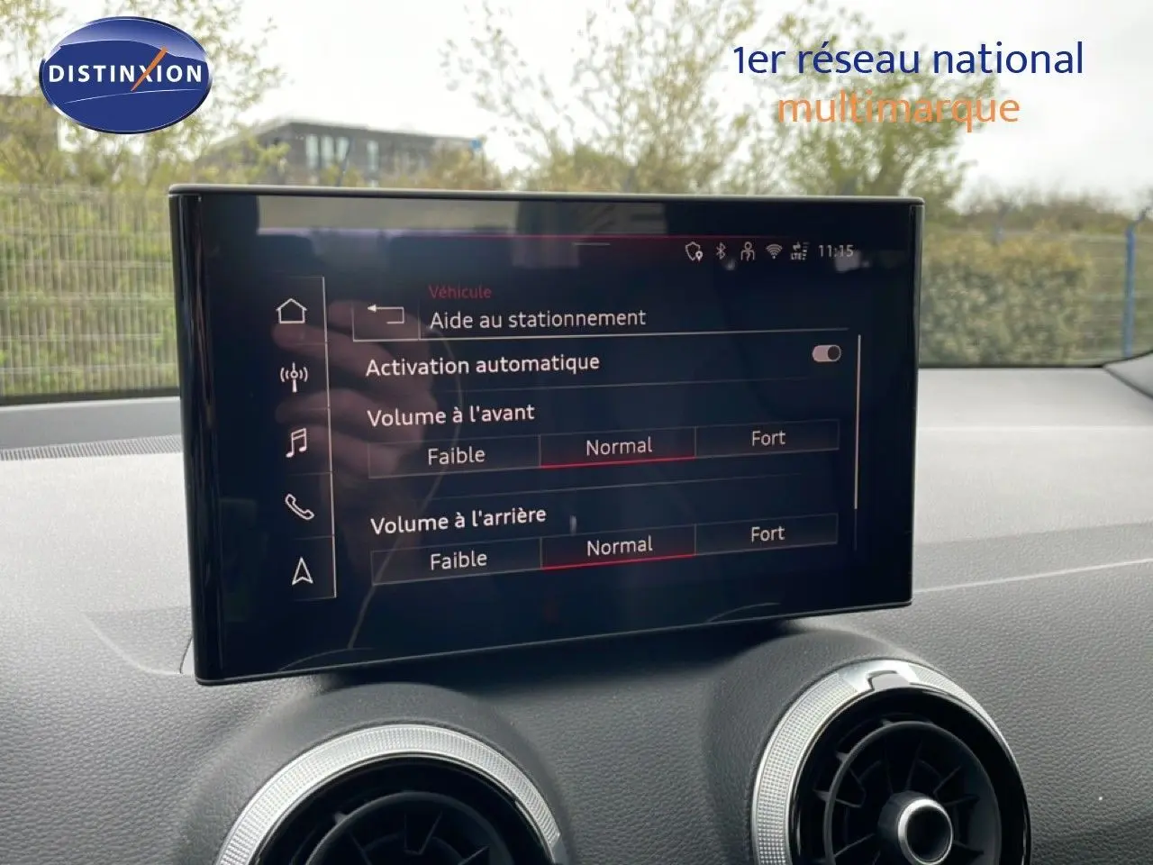 Écran central de l’Audi Q2 noir mito metal 2025 affichant les réglages d’aide au stationnement et volume sonore.