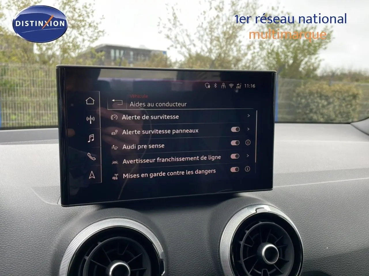 Écran tactile central affichant les aides à la conduite dans l’habitacle d’un Audi Q2 noir mito metal.