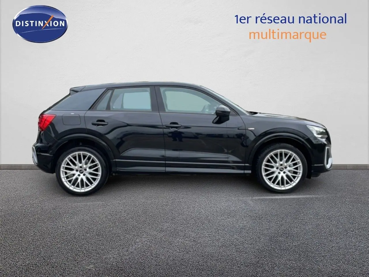 Profil côté gauche d'un Audi Q2 noir mito metal 2025 avec jantes alliage et finition S-Line visible sur fond neutre.