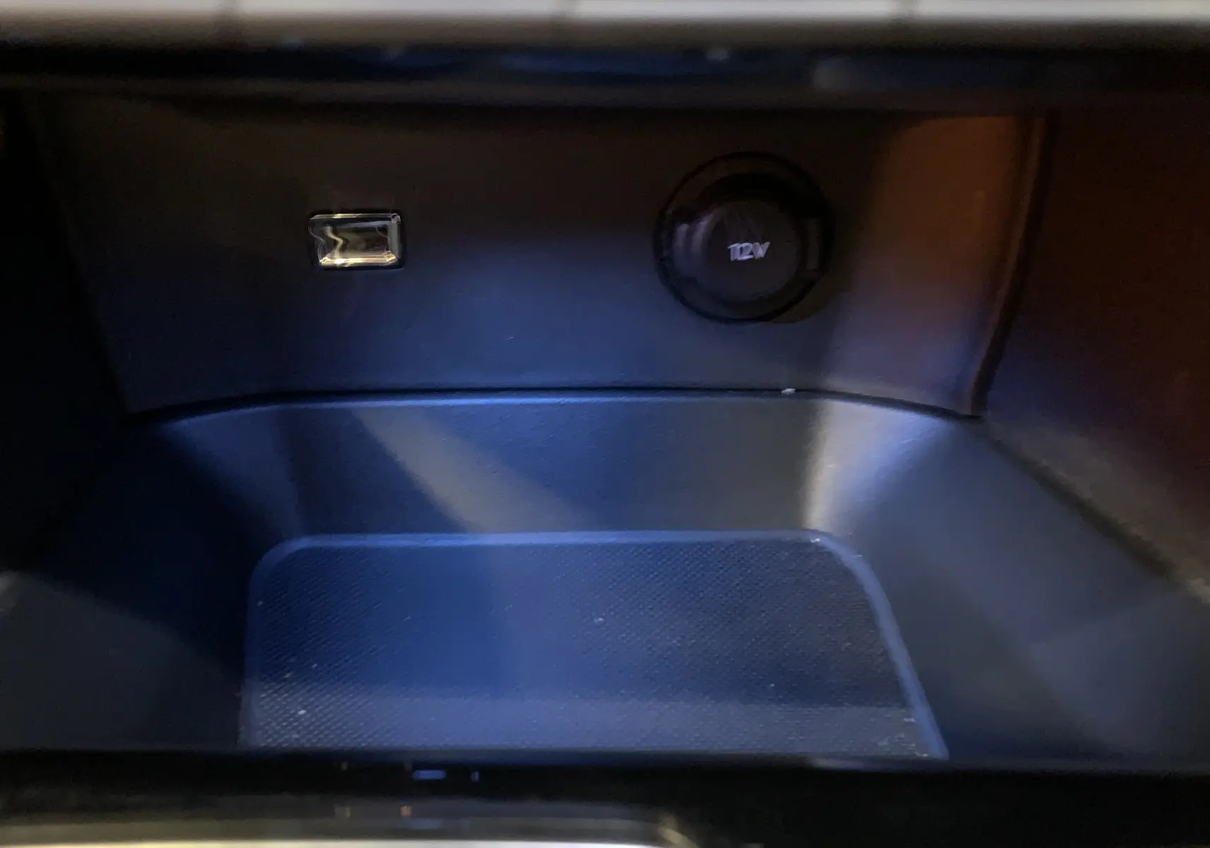 Détail de la prise 12V et port USB dans le rangement intérieur du Peugeot 5008 Bleu Célèbes 2024.
