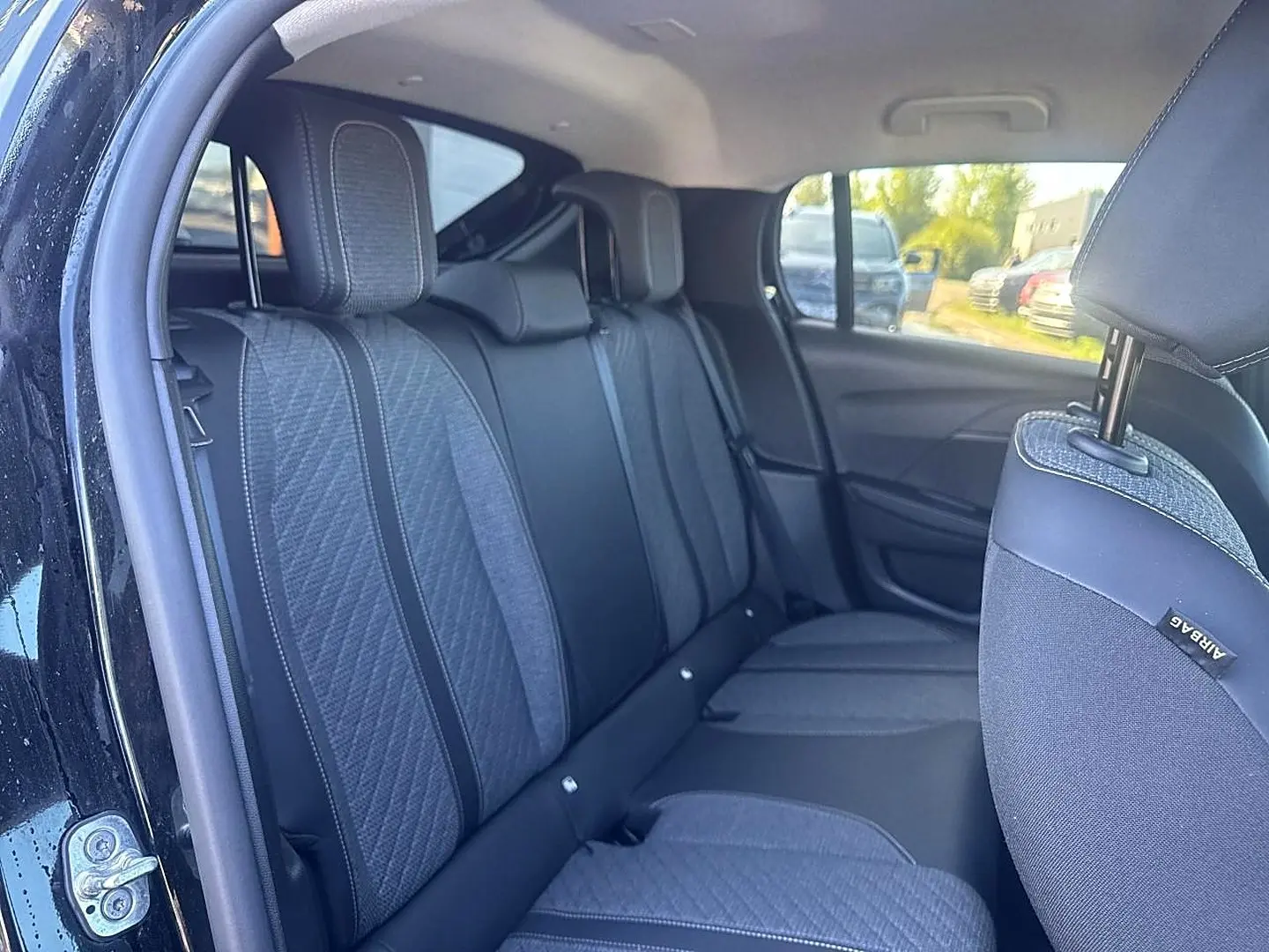 Vue intérieure côté gauche de la banquette arrière tissu gris et noir de la Peugeot 208 1.2 100 Allure noire 2025.