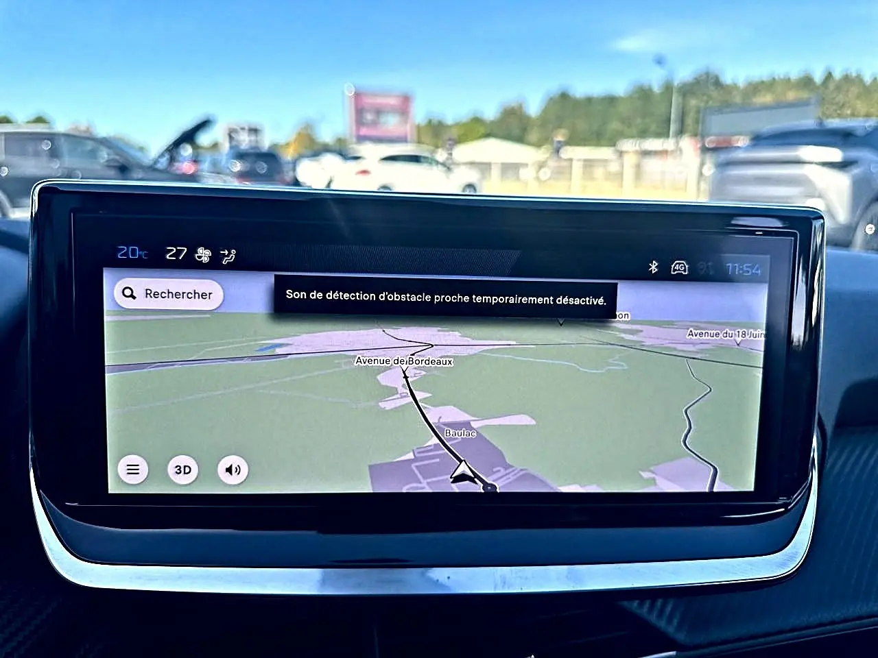 Écran tactile central du tableau de bord de la Peugeot 208 noir, affichant la navigation GPS en extérieur.
