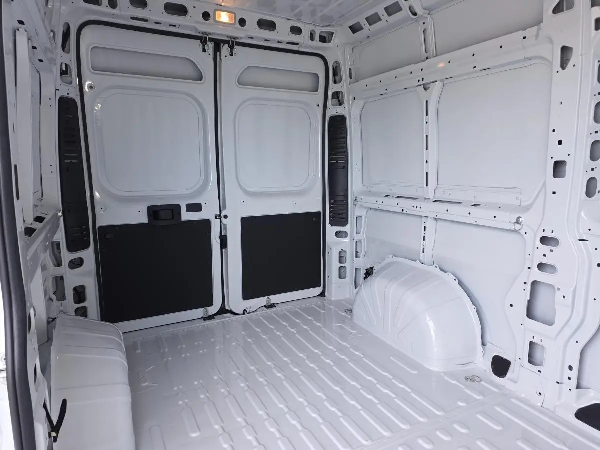 Vue intérieure arrière du fourgon FIAT Ducato Tôlé blanc 2025, montrant l’espace de chargement tôlé et les portes battantes.