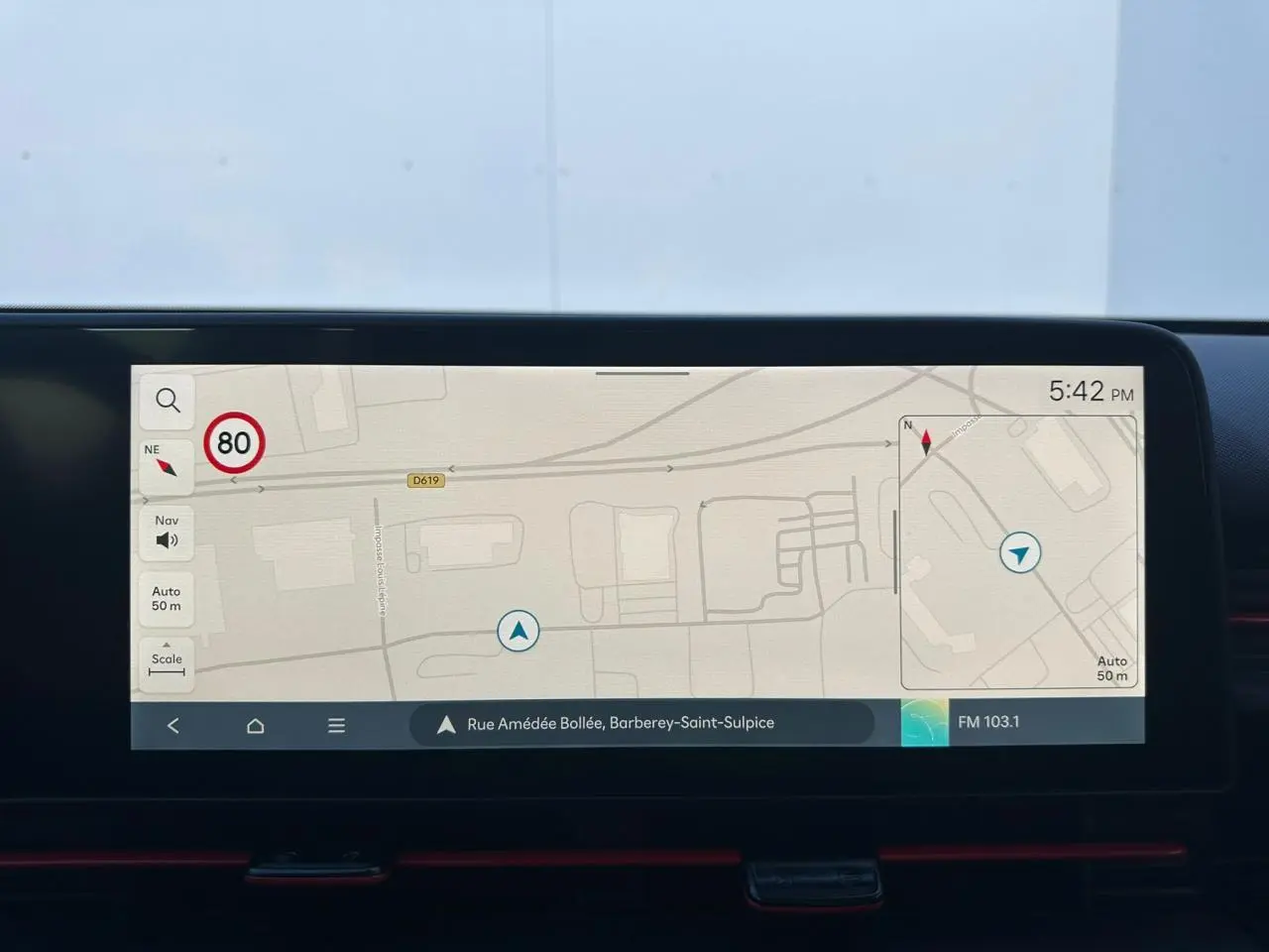 Vue plongeante sur l'accoudoir central noir et les sièges avant noirs avec surpiqûres rouges du Hyundai Kona 2026.