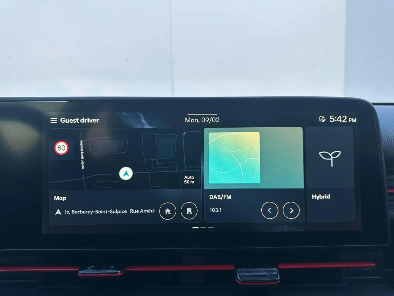 Vue plongeante sur la console centrale noire du Hyundai Kona 2026 avec porte-gobelets et commandes Drive Mode.