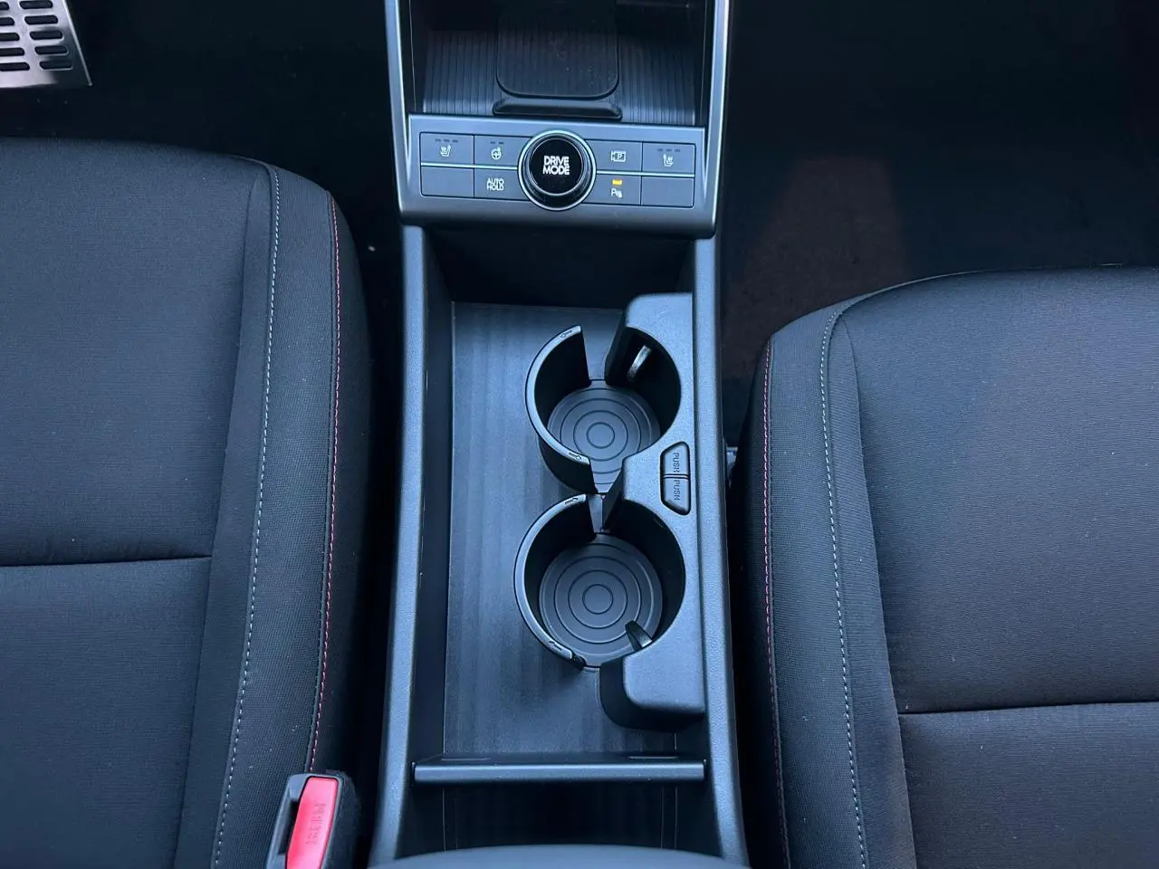 Vue rapprochée du volant cuir noir à surpiqûres rouges du Hyundai KONA 2026 avec tableau de bord numérique.