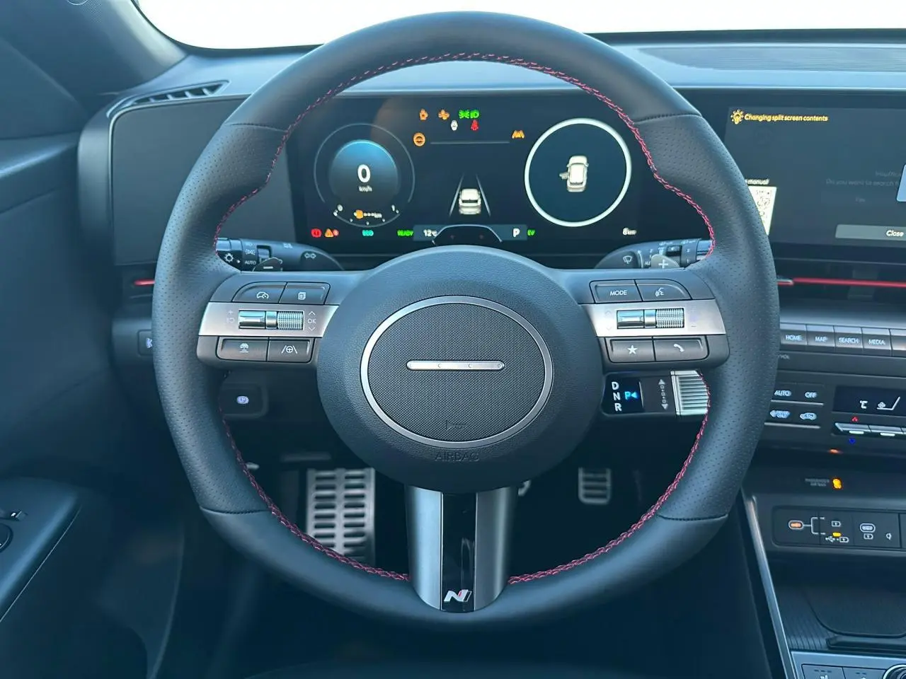 Vue 3/4 arrière droite du Hyundai KONA II hybride en gris métallisé Ecotronic, avec feux arrière LED et double sortie d'échappement.