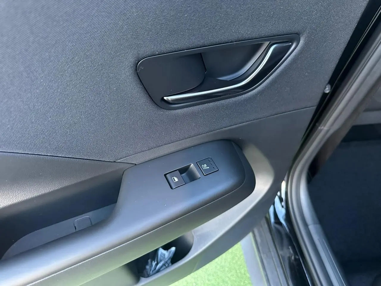 Détail de la porte arrière droite du Hyundai Kona 2026 gris Ecotronic avec commandes de vitre et verrouillage.