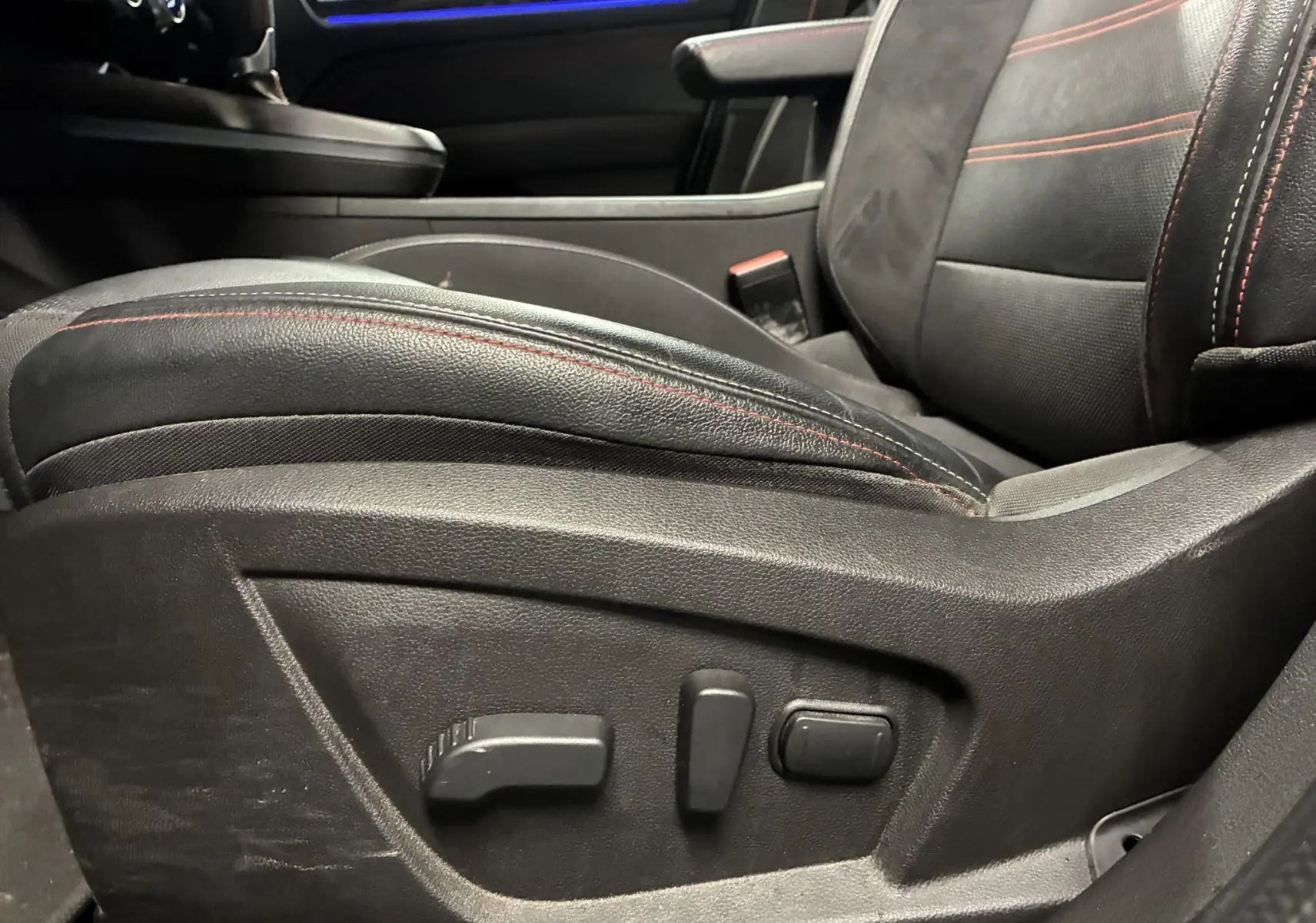 Gros plan sur le siège avant gauche en cuir noir avec surpiqûres rouges du Renault Arkana 1.3 TCE 140 RS-LINE 2021.