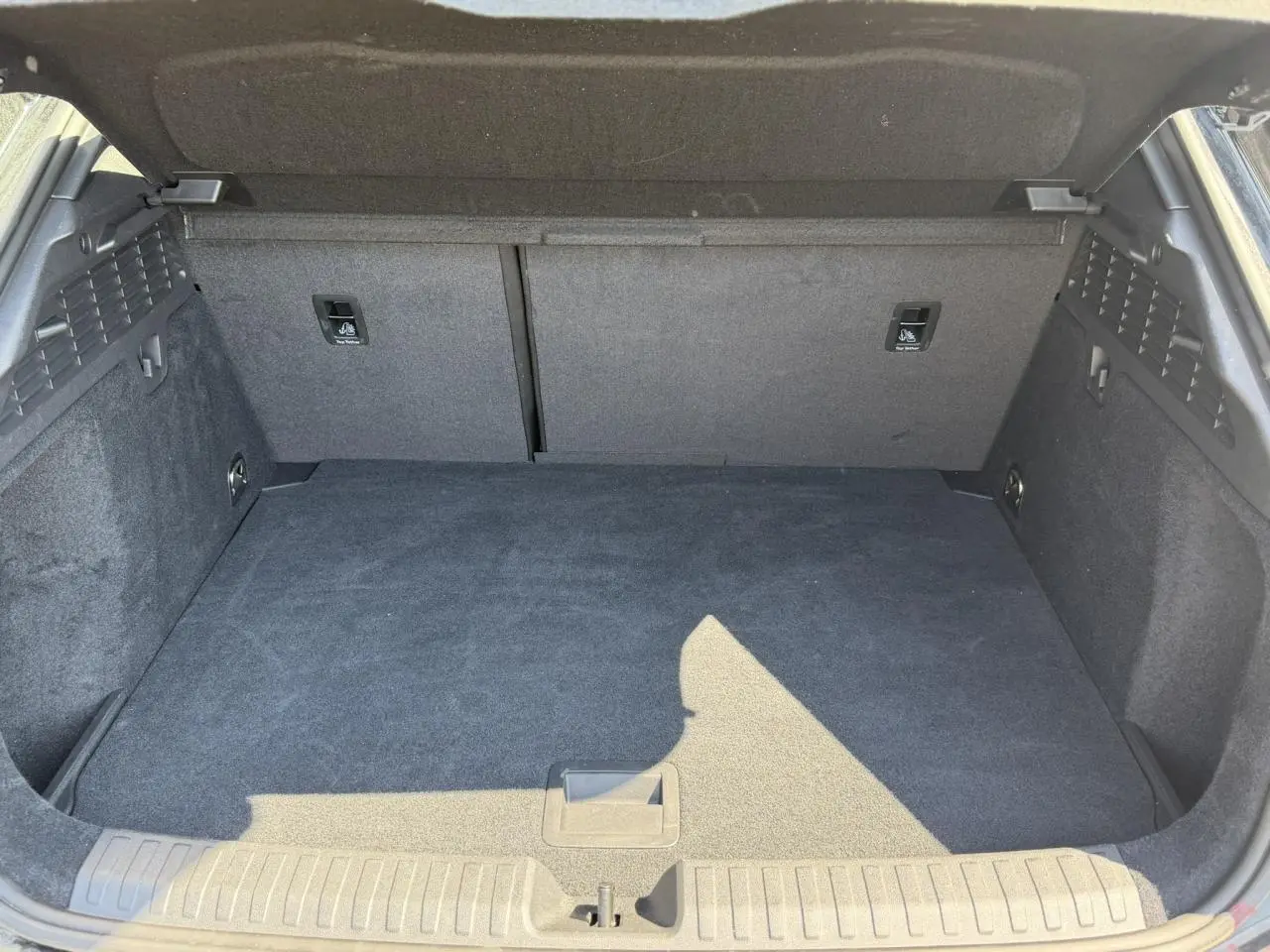 Coffre ouvert de l'Audi A3 Sportback noir Mythe, vue intérieure montrant l'espace de chargement et les fixations Top Tether.