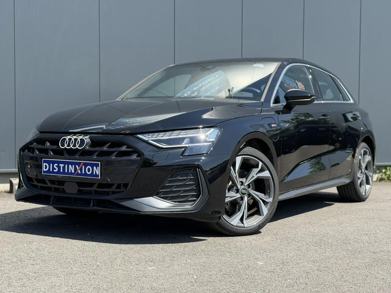Audi A3 Sportback noir mythe vue 3/4 avant droit avec jantes alliage 5 branches en Y gris brillant.