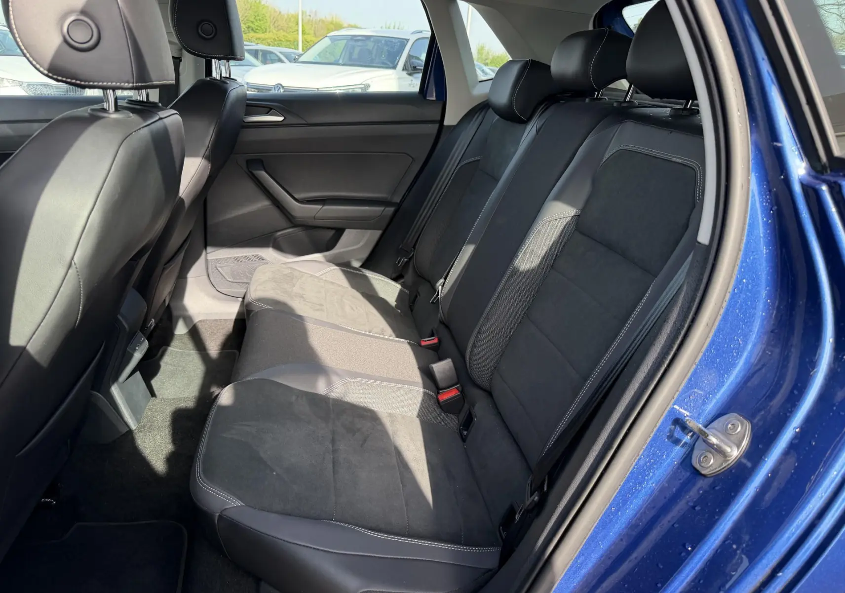 Vue intérieure côté droit des sièges arrière en tissu noir et cuir d'une Volkswagen Polo 2025 bleu récif métallisé.