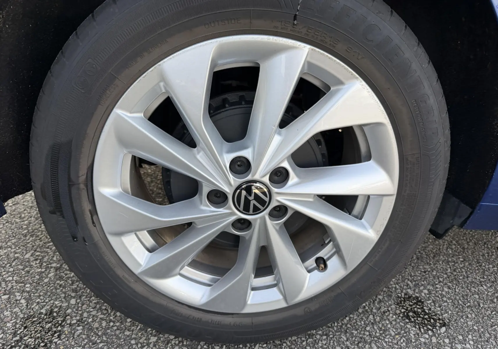 Gros plan sur la jante alliage 16'' Palermo argentée d'une Volkswagen Polo bleu récif métallisé, roue avant droite.