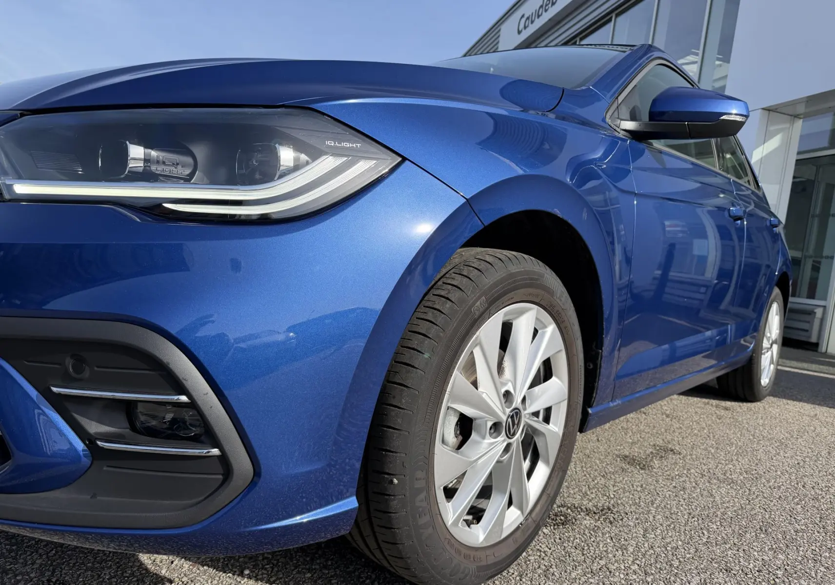 Vue 3/4 avant droit d'une Volkswagen Polo bleue métallisée avec phares IQ.Light et jantes alliage 16 pouces.