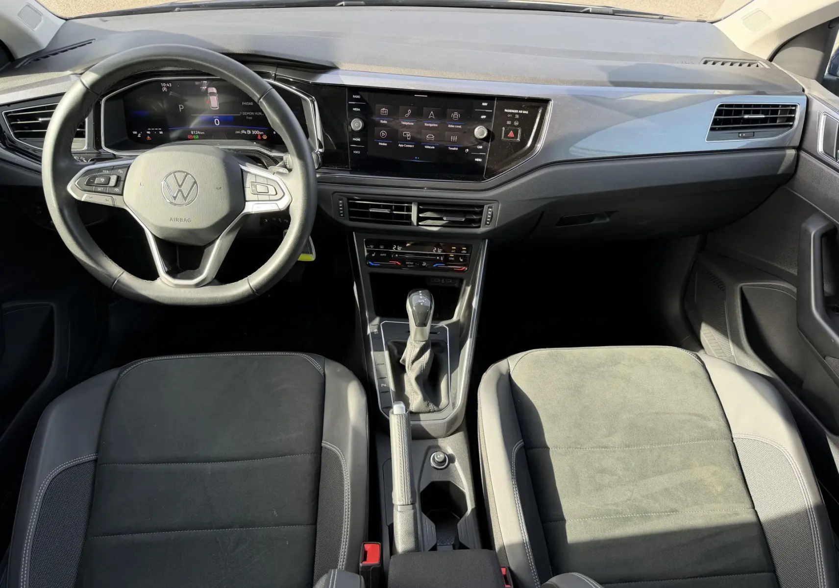 Vue intérieure avant de la Volkswagen Polo 2025, tableau de bord moderne avec écran tactile et volant multifonctions cuir.