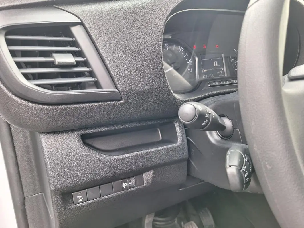 Détail de l’intérieur côté gauche du tableau de bord noir de l’Opel Vivaro 2025 avec commandes et aérateur.