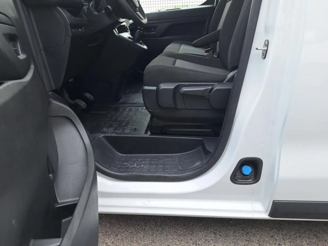 Vue intérieure côté conducteur de l’Opel Vivaro blanc 2025, montrant les sièges et le tableau de bord partiel.