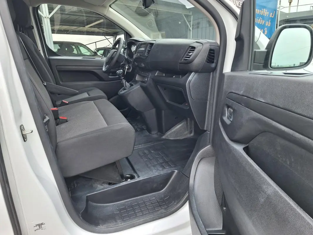 Vue intérieure côté conducteur de l’Opel Vivaro blanc 2025, montrant les sièges avant et le tableau de bord.