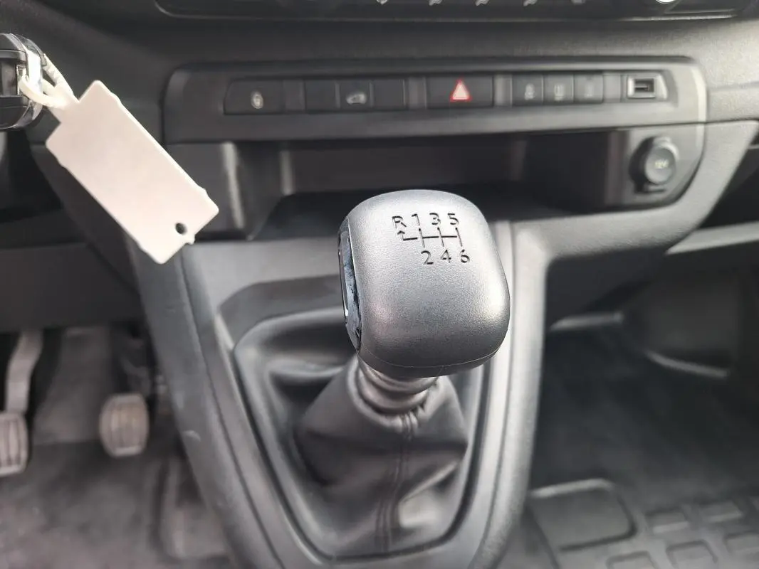 Gros plan sur le levier de vitesses manuel noir de l’Opel Vivaro 2025, intérieur gris et tableau de bord sobre.