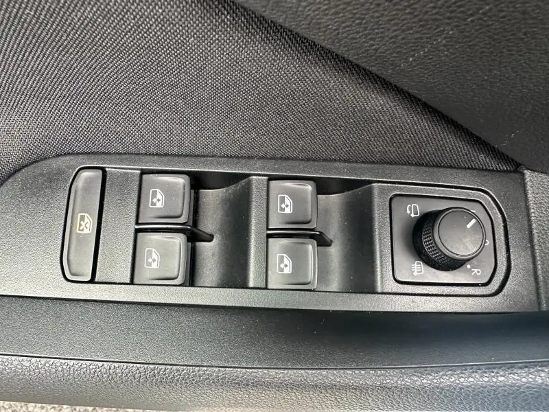 Vue rapprochée des commandes de lève-vitres et réglage des rétroviseurs sur la porte côté conducteur d’une Skoda Scala blanc cristal.