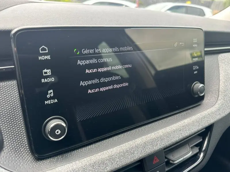 Écran tactile central de la Skoda Scala blanc cristal, vue rapprochée du système multimédia avec commandes tactiles.
