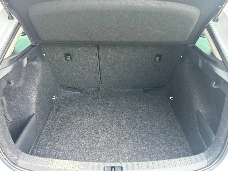 Coffre ouvert vu de l'arrière d'une Skoda Scala blanc cristal, espace de chargement propre et spacieux.