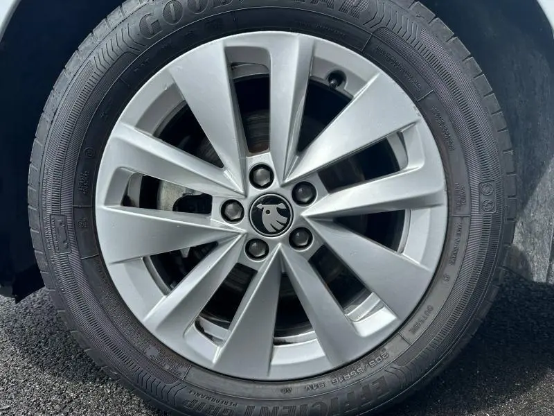 Gros plan sur la jante alu argentée avec logo ŠKODA noir au centre, montée sur pneu Goodyear.