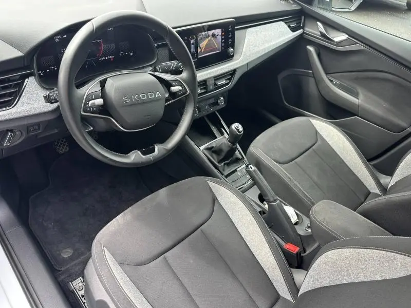 Vue intérieure côté conducteur de la Skoda Scala 2025, volant cuir multifonction et sièges tissu noir/gris.