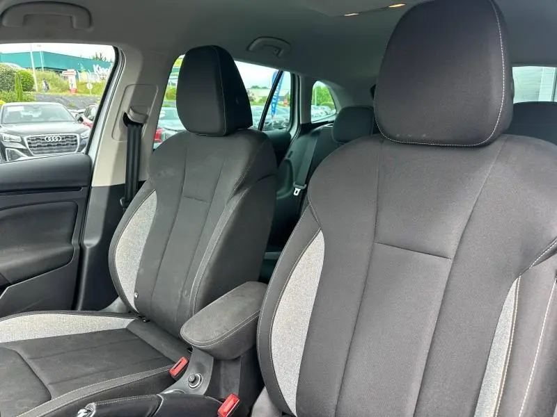 Vue intérieure des sièges avant en tissu noir et gris d'une Skoda Scala 2025, avec accoudoir central côté droit.