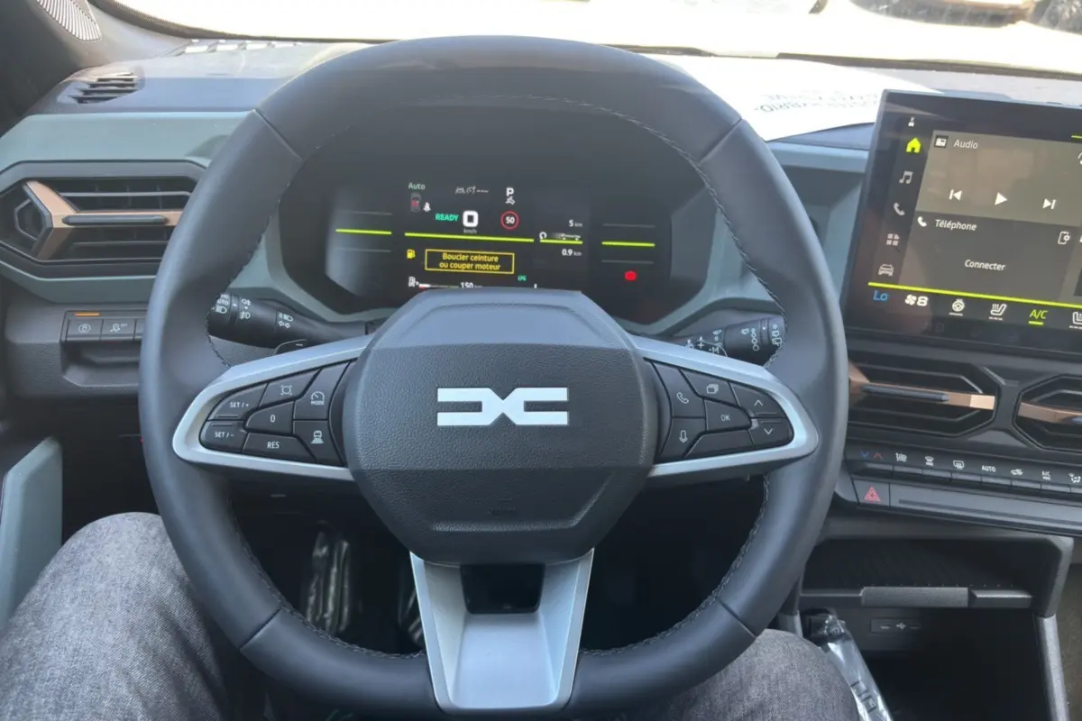 Vue rapprochée du volant cuir noir et du tableau de bord numérique du Dacia Duster Hybrid-G 150 4x4 Extreme City 2026.