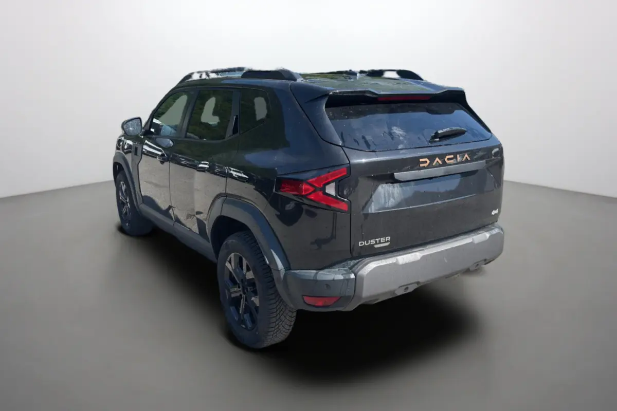 Vue 3/4 arrière droite d'un Dacia Duster noir nacré avec barres de toit et vitres surteintées.