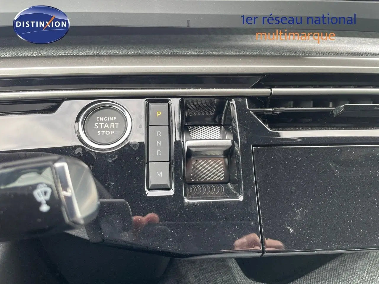 Détail de la console centrale noire brillante du Peugeot 3008 Hybrid 2025 avec bouton start/stop et commandes de boîte automatique.