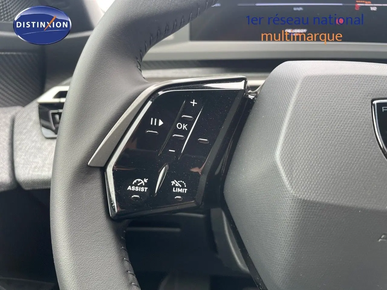 Gros plan sur les commandes à gauche du volant noir du Peugeot 3008 Hybrid 2025, soulignant les fonctions assist et limitateur.