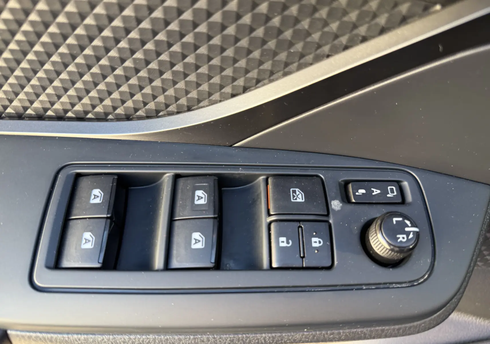 Panneau de commandes des vitres et rétroviseurs côté gauche intérieur d’un Toyota C-HR bleu Nebula Metal 2018.